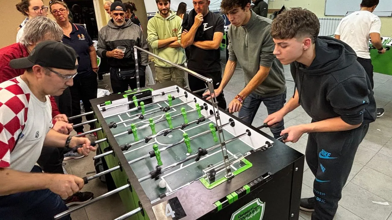 Jugadores y público alrededor de varios futbolines en Carabaña